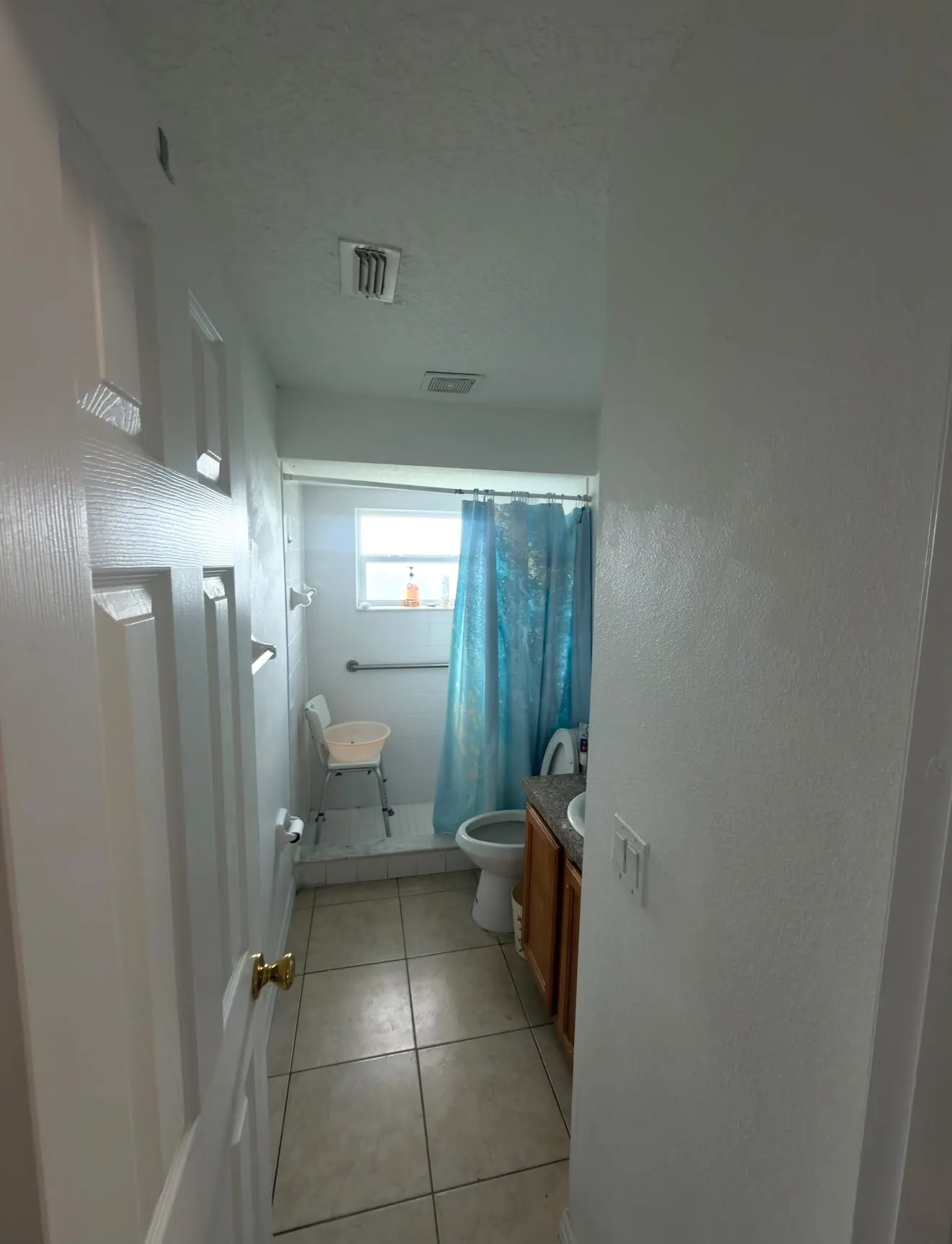 Plain white bathroom with shower curtain before remodeling