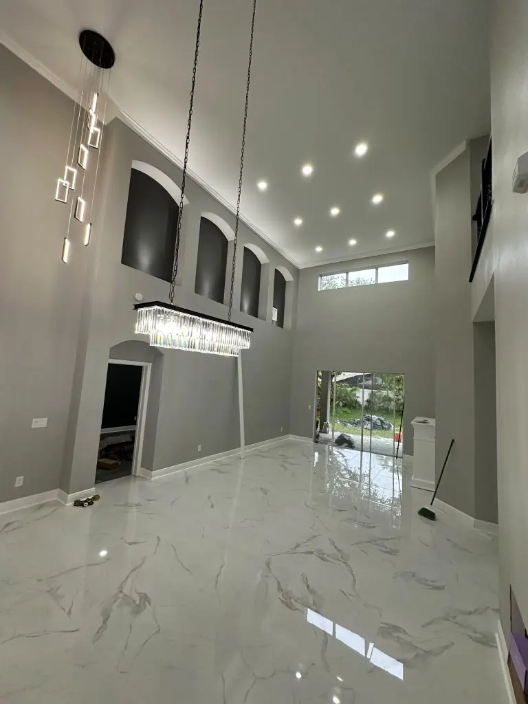 Double-height living room with large-format marble-look porcelain flooring