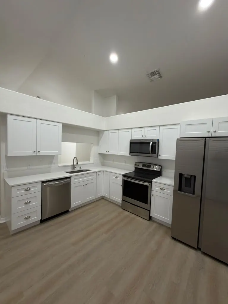 Remodeled kitchen with white shaker cabinets, quartz countertops and stainless appliances