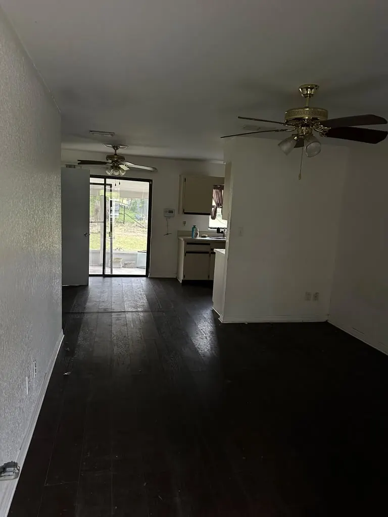 Dark dated living area with worn flooring before remodeling
